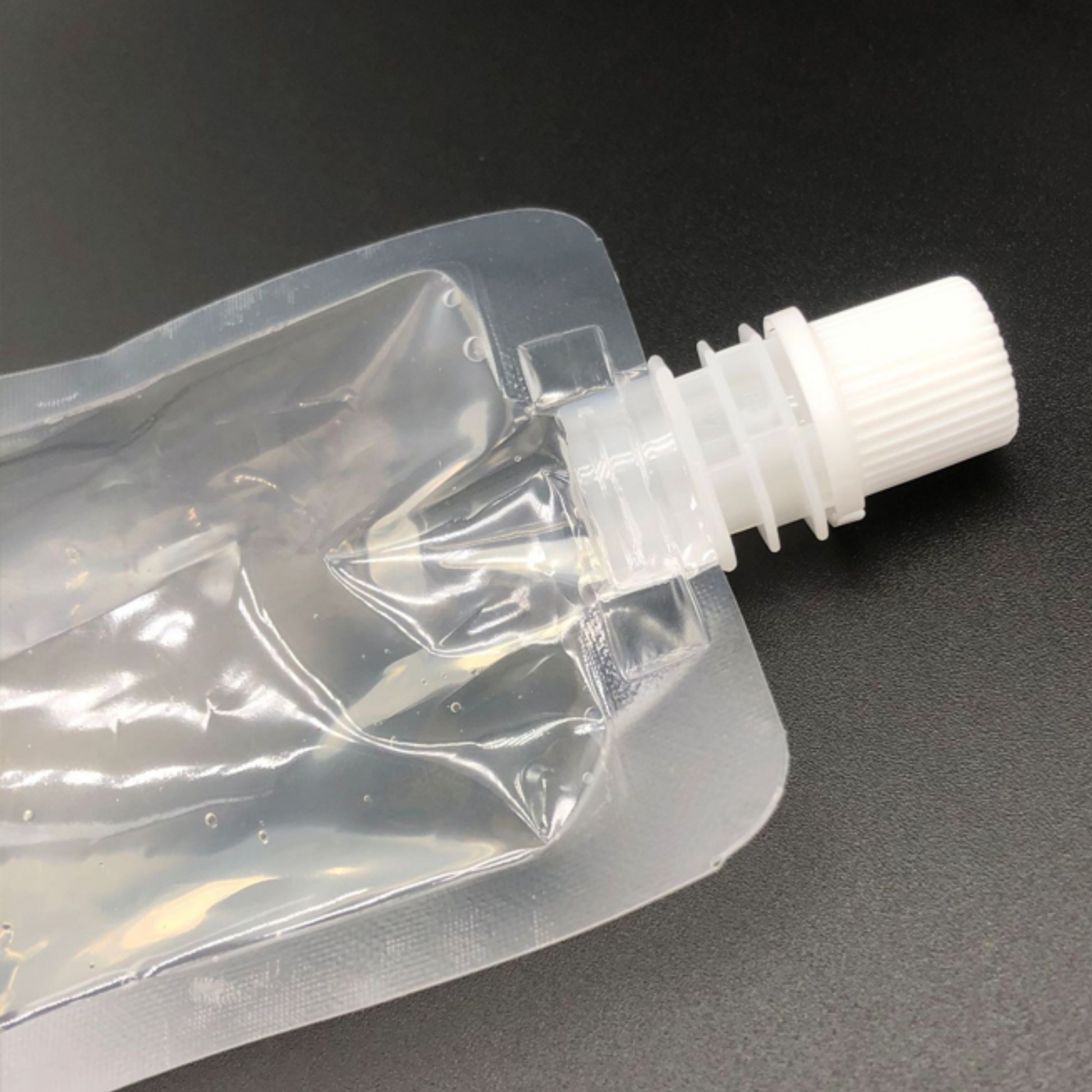 Transparent stand-up pouch with spout and stable base for shelf display