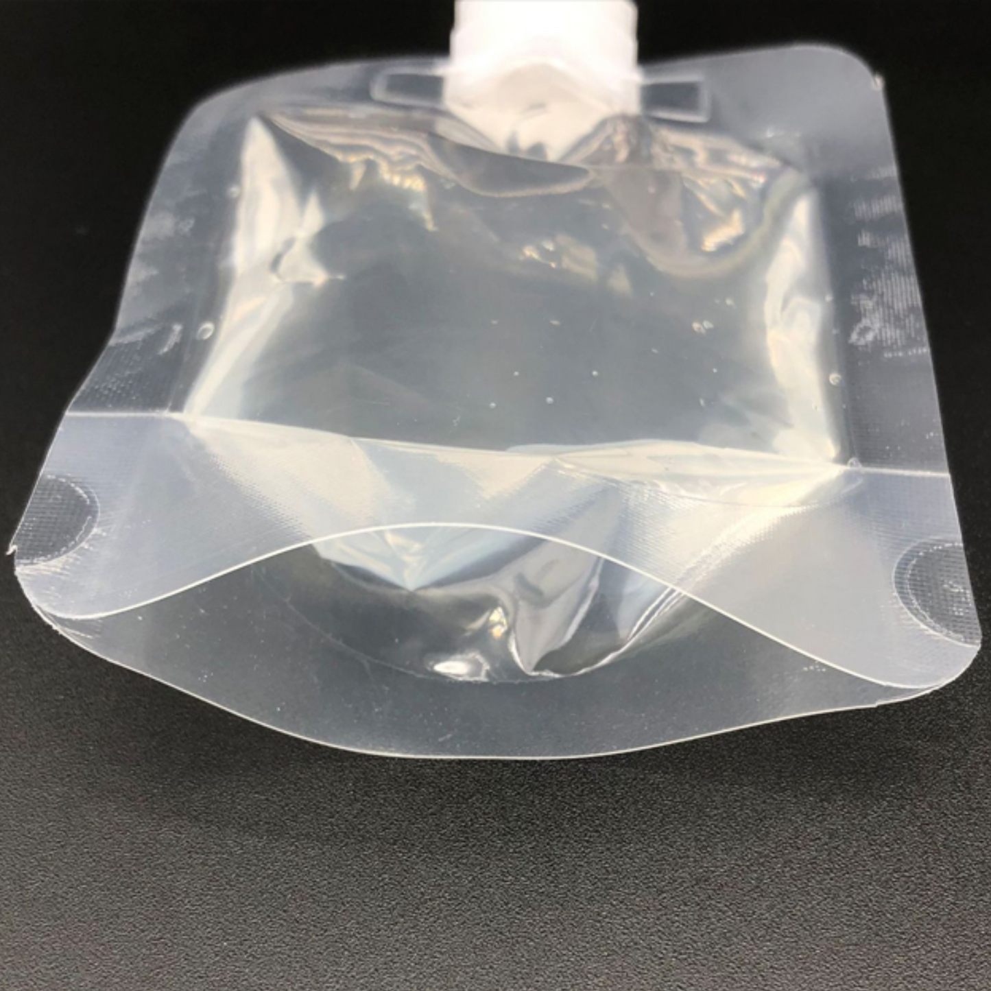 Leak-resistant spout with self-seal cap on clear PET + PE stand-up pouch
