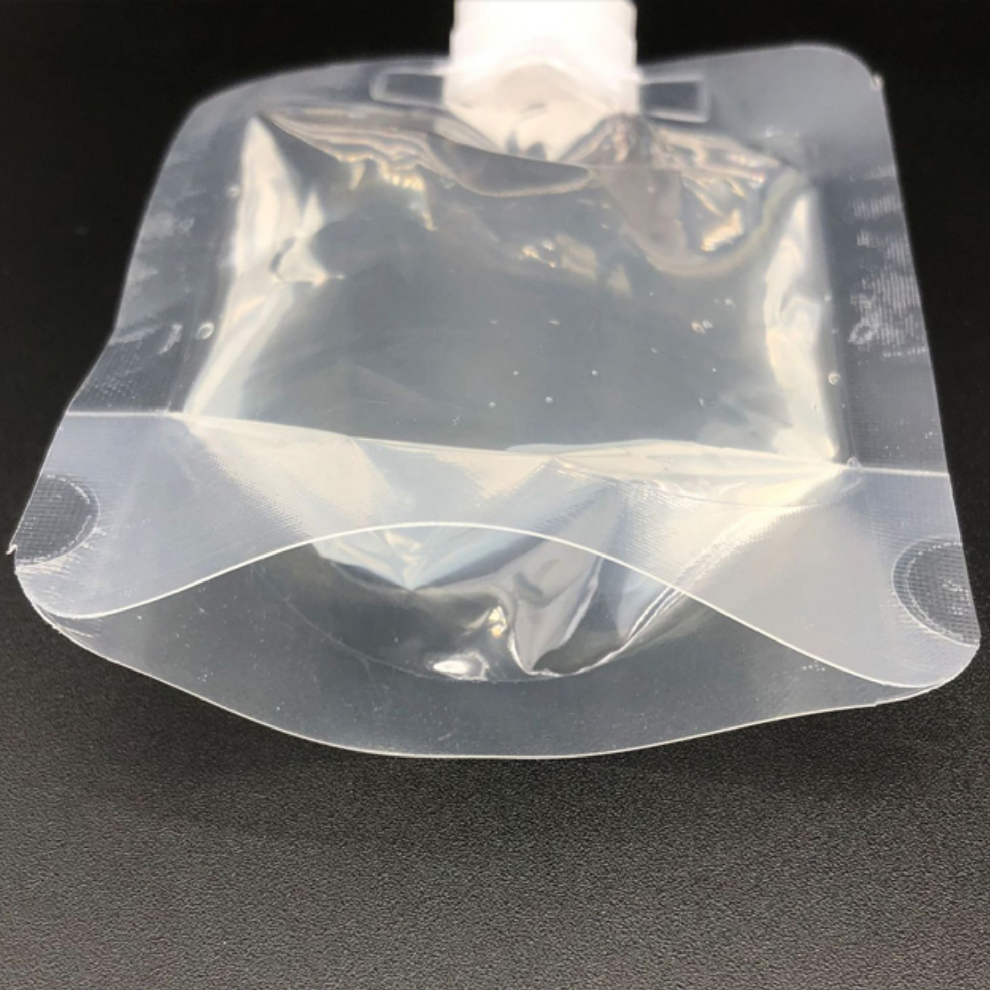 Leak-resistant spout with self-seal cap on clear PET + PE stand-up pouch